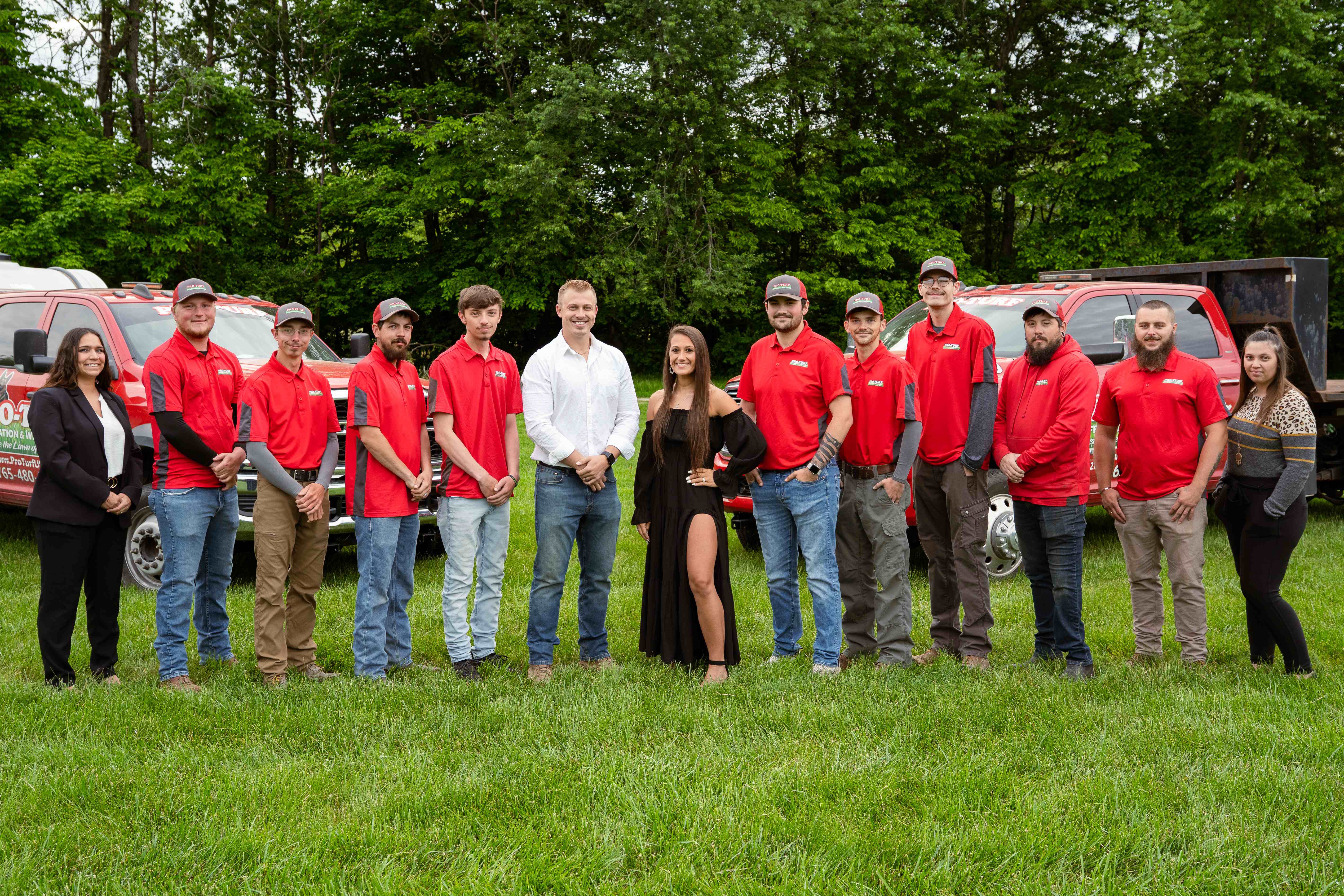Pro-Turf team standing together on beautiful green lawn with company trucks