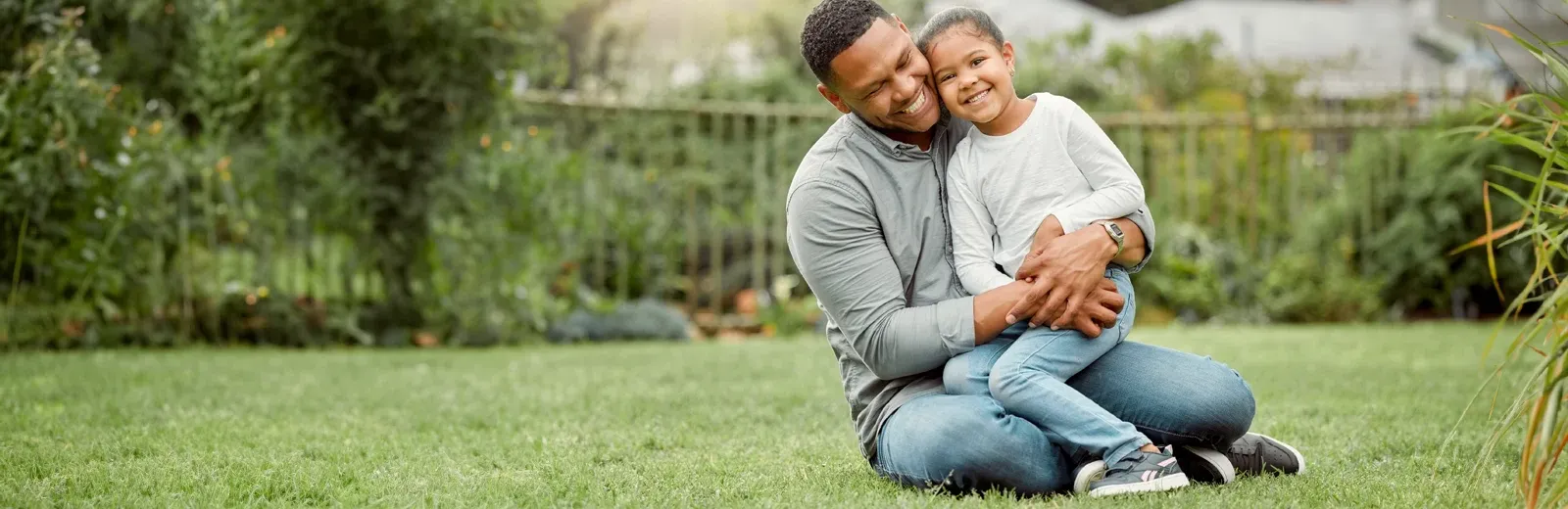 father and daughter playing outside in green healthy lawn