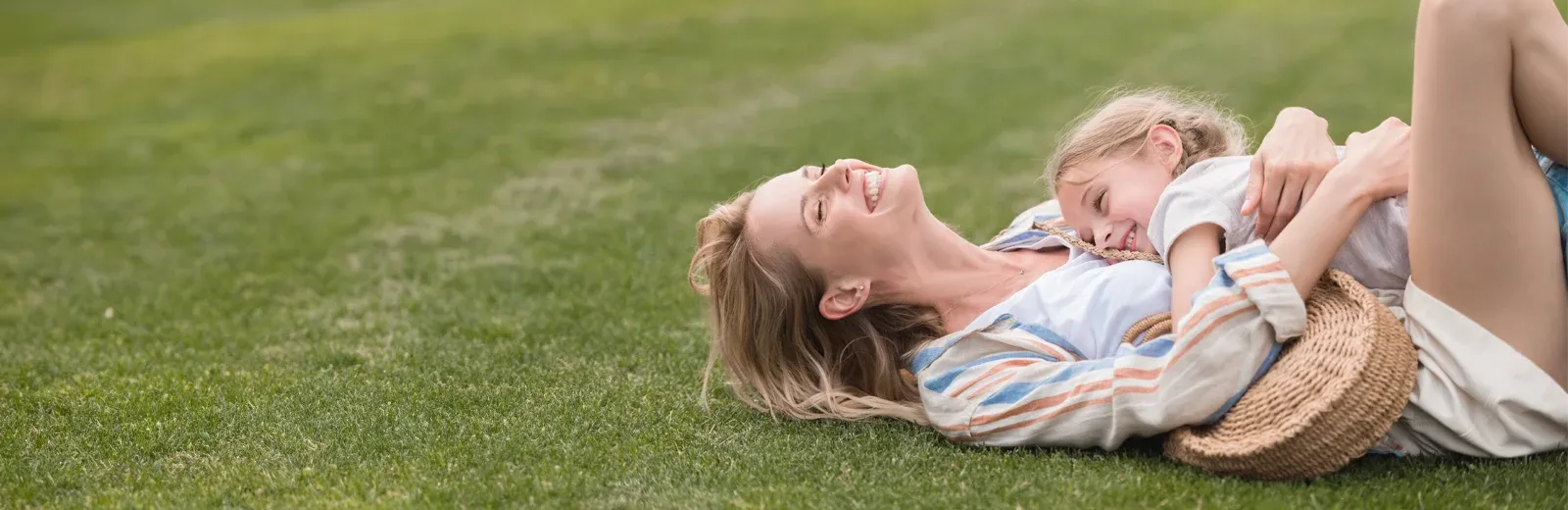 mother and daughter laughing outside playing in yard