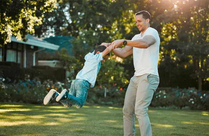 Father and son playing outside in front yard